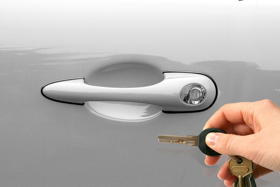 man holding car keys in front of a car door