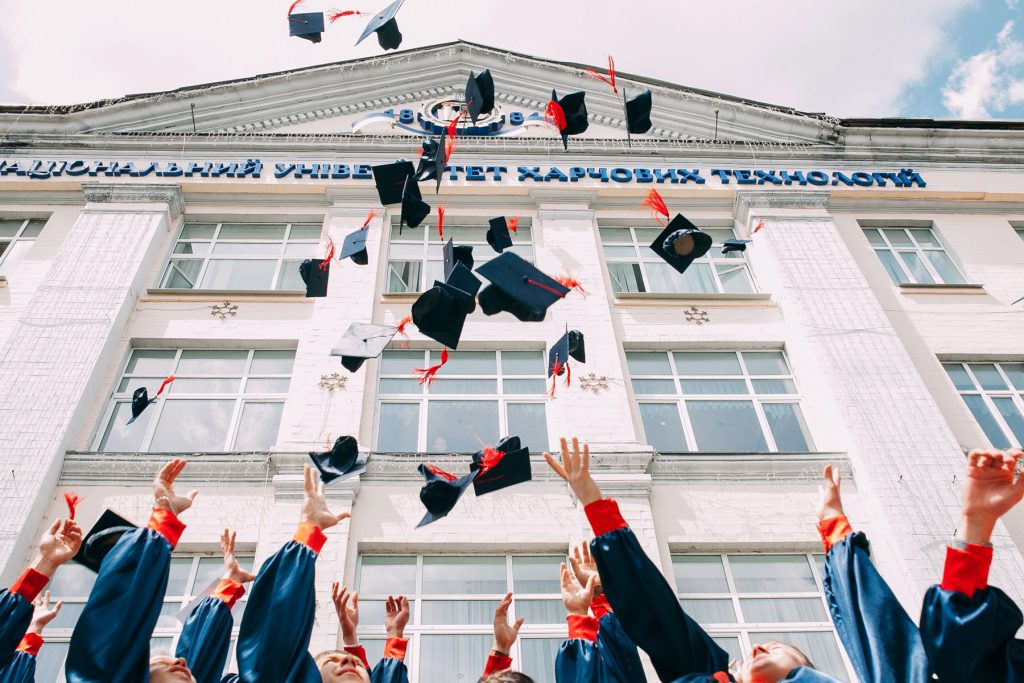 Graduates throwing caps in joy.