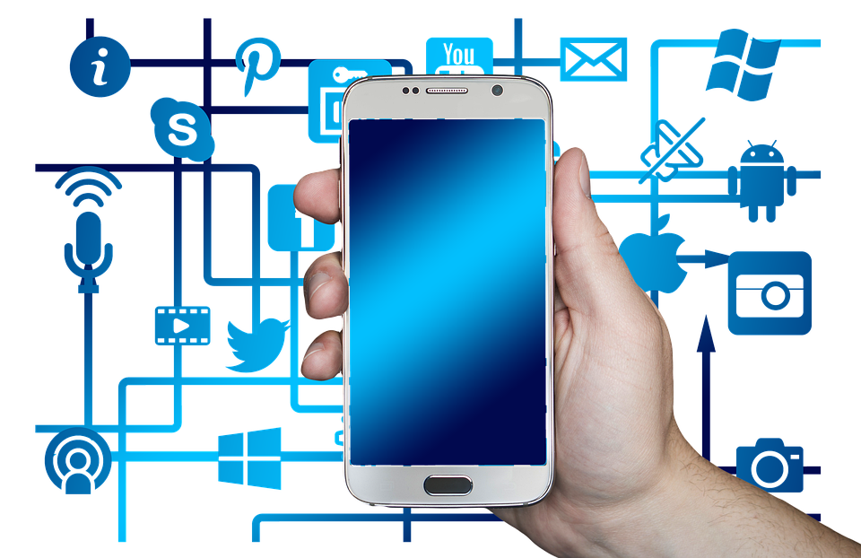 man holding a smartphone with social media icons in background